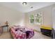Bright bedroom with a window overlooking the yard and a colorful blanket on the bed at 4994 Willow Creek Dr, Woodstock, GA 30188