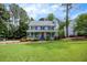 Traditional two-story home with a lovely porch, mature trees, and well-manicured lawn at 4994 Willow Creek Dr, Woodstock, GA 30188
