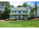 Charming two-story home with a welcoming front porch and lush green lawn at 4994 Willow Creek Dr, Woodstock, GA 30188