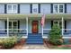 Welcoming front porch with a charming entrance and an American flag at 4994 Willow Creek Dr, Woodstock, GA 30188