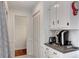 Well-organized kitchen featuring white cabinets, an appliance station, and an adjacent doorway at 4994 Willow Creek Dr, Woodstock, GA 30188