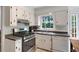 Charming kitchen with a stove, stainless steel appliances, white cabinets, and a garden view at 4994 Willow Creek Dr, Woodstock, GA 30188