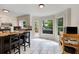 Sunlit kitchen with stainless steel appliances, an island, white cabinets, and outdoor views at 4994 Willow Creek Dr, Woodstock, GA 30188