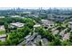 An aerial view showcases the community nestled among lush trees with a pool and the Atlanta skyline in the distance at 1346 Peter Haughton Nw Way, Atlanta, GA 30318