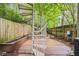 Backyard with a spiral staircase leading to a deck area and lush landscaping at 1346 Peter Haughton Nw Way, Atlanta, GA 30318