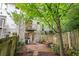 View of the private backyard with wooden patio, trees, spiraling staircases, and fence at 1346 Peter Haughton Nw Way, Atlanta, GA 30318