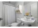 Minimalist bathroom featuring a white pedestal sink and a shower with a white curtain at 1346 Peter Haughton Nw Way, Atlanta, GA 30318