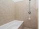 Tiled bathroom shower and tub combination with modern fixtures and a hand-held sprayer at 1346 Peter Haughton Nw Way, Atlanta, GA 30318