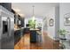Open kitchen flowing into the living area has dark cabinetry, an island with seating, and wood floors at 1346 Peter Haughton Nw Way, Atlanta, GA 30318