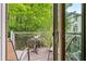 Outdoor patio view shows seating, a small table, and green foliage in a private setting at 1346 Peter Haughton Nw Way, Atlanta, GA 30318