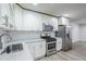 Beautiful kitchen featuring stainless steel appliances, white cabinets, stylish subway tile backsplash, and sleek countertops at 3735 Boulder Park Sw Dr, Atlanta, GA 30331