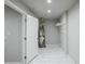 Neat utility room with white tile flooring, hot water heater, and storage shelving at 3735 Boulder Park Sw Dr, Atlanta, GA 30331