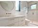 Modern bathroom with marble tile, a round mirror, and gold fixtures in a naturally lit space at 1572 Clifton Rdg, Atlanta, GA 30307