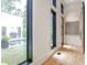 Hallway with dark framed windows showcasing the pool and backyard, and light hardwood flooring throughout at 1572 Clifton Rdg, Atlanta, GA 30307