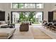 Open-concept living room with a wall of windows overlooking a private backyard and pool area at 1572 Clifton Rdg, Atlanta, GA 30307