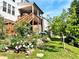 Backyard view showcasing a wooden deck, flourishing garden, and a neatly kept lawn at 4071 Woodward Walk Ln, Suwanee, GA 30024
