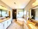 Bathroom featuring dual vanities, a soaking tub, and glass enclosed shower at 4071 Woodward Walk Ln, Suwanee, GA 30024
