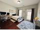 Bedroom with dark wood floors, a desk and computer, a bed, and access to a balcony at 4071 Woodward Walk Ln, Suwanee, GA 30024