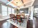 Elegant dining room boasts hardwood floors, coffered ceilings, and modern lighting fixture at 4071 Woodward Walk Ln, Suwanee, GA 30024