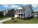 Inviting two-story home with a spacious yard, beautiful landscaping, and a welcoming front porch at 4071 Woodward Walk Ln, Suwanee, GA 30024