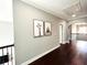 Hallway featuring hardwood floors and decorative wall art, seamlessly connecting living spaces with artistic flair at 4071 Woodward Walk Ln, Suwanee, GA 30024