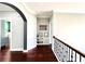 Bright hallway featuring hardwood floors, display cabinet and decoratively framed entranceway at 4071 Woodward Walk Ln, Suwanee, GA 30024