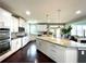 Modern kitchen with white cabinets, stainless steel appliances, granite countertops, and a view to the living area at 4071 Woodward Walk Ln, Suwanee, GA 30024