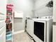 Functional laundry room featuring a full-sized washer and dryer and ample storage racks at 4071 Woodward Walk Ln, Suwanee, GA 30024