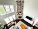 Aerial view of the living room, showcasing the floor-to-ceiling stone fireplace, large windows, and comfortable furniture at 4071 Woodward Walk Ln, Suwanee, GA 30024