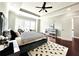 Main bedroom with gray walls, a trey ceiling, dark floors, and light filled windows at 4071 Woodward Walk Ln, Suwanee, GA 30024