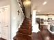 Wooden staircase with iron spindles and adjacent entry door, next to a kitchen with granite countertops at 4071 Woodward Walk Ln, Suwanee, GA 30024