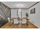 Bright dining room with modern lighting, hardwood floors, table with white chairs, and black accent wall at 4576 Dorset Circle, Decatur, GA 30035