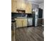 Traditional kitchen featuring stainless steel appliances, custom cabinets, dark countertops, and wood flooring at 497 Natasha Dr, Auburn, GA 30011