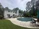 Expansive backyard featuring a covered pool, patio furniture, and a serene wooded backdrop at 3 Perthshire Dr, Peachtree City, GA 30269