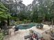 The covered pool is surrounded by patio, lounge chairs, umbrellas, and verdant trees at 3 Perthshire Dr, Peachtree City, GA 30269