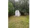 Backyard shed with decorative accents, nestled among mature trees and green grass at 3 Perthshire Dr, Peachtree City, GA 30269