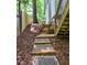 Landscaped backyard features a stone paver walkway and wooden retaining wall leading to the house at 5105 Tynewick Ne Trce, Roswell, GA 30075