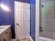 Bright bathroom featuring a classic white door, modern shower, and stylish vanity against a blue wall at 5105 Tynewick Ne Trce, Roswell, GA 30075