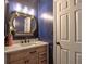 Charming bathroom with custom vanity, decorative mirror, and a classic white door against a bold blue wall at 5105 Tynewick Ne Trce, Roswell, GA 30075