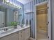 Bathroom features patterned wallpaper, a double vanity, and a shower-tub combination at 5105 Tynewick Ne Trce, Roswell, GA 30075