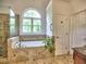 Elegant bathroom featuring a glass shower and luxurious soaking tub with tile surround and window at 5105 Tynewick Ne Trce, Roswell, GA 30075