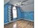 Bright bedroom with blue walls, hardwood floors, a ceiling fan, and built-in shelving at 5105 Tynewick Ne Trce, Roswell, GA 30075