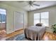 Cozy bedroom featuring hardwood floors, a ceiling fan, and a light-filled window, next to the bathroom at 5105 Tynewick Ne Trce, Roswell, GA 30075