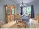 Bright dining room featuring hardwood floors, a chandelier, and a large cabinet near the window at 5105 Tynewick Ne Trce, Roswell, GA 30075
