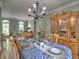 Open dining room with a beautifully set table, teddy bear accents, and a decorative cabinet at 5105 Tynewick Ne Trce, Roswell, GA 30075