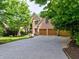 Inviting brick home featuring an attached two-car garage and a wide driveway at 5105 Tynewick Ne Trce, Roswell, GA 30075