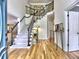 Elegant foyer with hardwood floors, a staircase with iron railings, and an open doorway at 5105 Tynewick Ne Trce, Roswell, GA 30075
