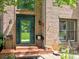 Close-up of a brick home's entrance with decorative door, porch seating, and manicured landscaping details at 5105 Tynewick Ne Trce, Roswell, GA 30075