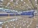 Spacious gymnasium with hardwood floors, basketball hoops, and blue bleacher seating at 5105 Tynewick Ne Trce, Roswell, GA 30075