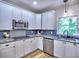 Bright kitchen features white cabinets, stainless steel appliances, and granite countertops at 5105 Tynewick Ne Trce, Roswell, GA 30075